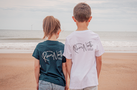 お揃いのTシャツを着た子供が海を眺めている