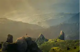 はさなる山々の配色を眺める男性