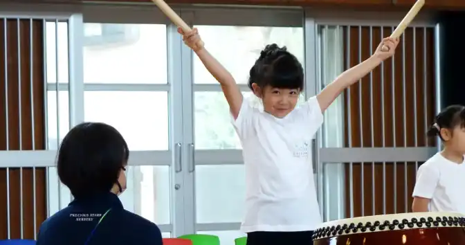 オリジナルデザインTシャツを着て太鼓を演奏している