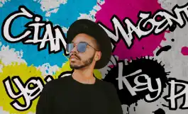 男性がCMYKと書かれた壁の前に佇んでいる。