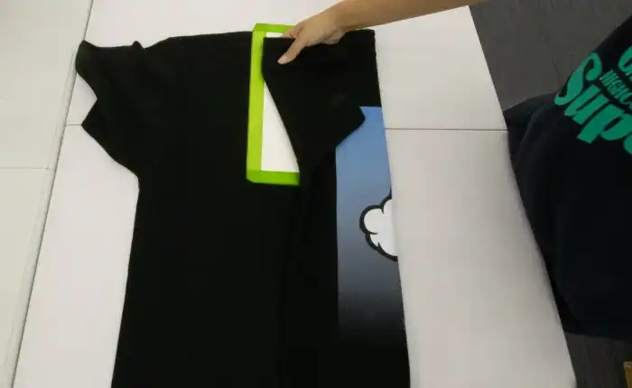 多くの検品を合格したTシャツを型で畳んでいく